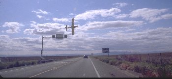 [Crop Duster buzzing road]