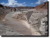 [ Hikers stand above the to ... ]